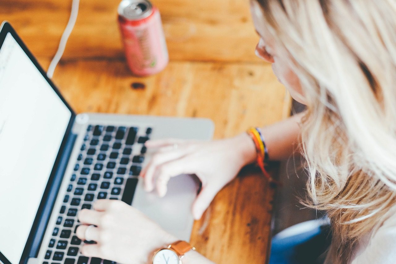 PHOTO OF WOMAN TYPING ON LAPTOP